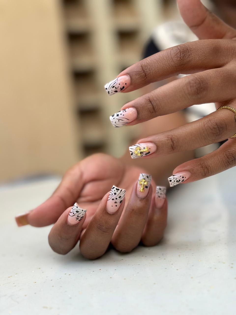 White nails with black leopard print and gold charms